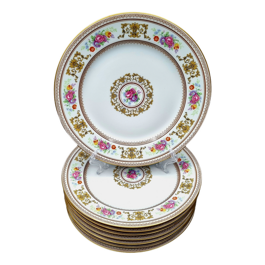 Grupo de 8 platos de porcelana de Limoges, marca Raynaud, decorados con orlas de flores y diseño central